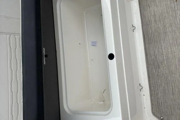 Slide: The Image of 2023 Sea Ray SPX 210 Outboard storage compartment, open and empty, with textured flooring. - 22