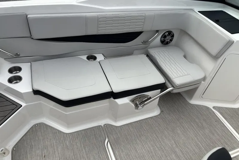 Slide: The Image of 2023 Sea Ray SPX 210 Outboard interior seating with cup holders and speaker. - 23