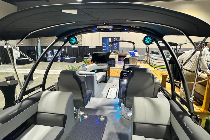 Slide: The Image of 2026 Veranda Relax VR235RC pontoon boat interior with modern seating and canopy at a boat show. - 15
