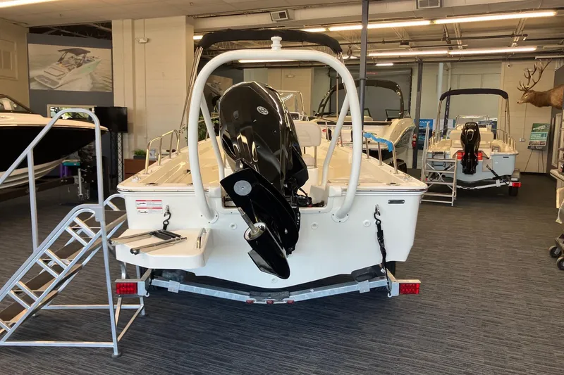 Slide: The Image of 2026 Boston Whaler 170 Montauk boat displayed in showroom with motor and trailer. - 3