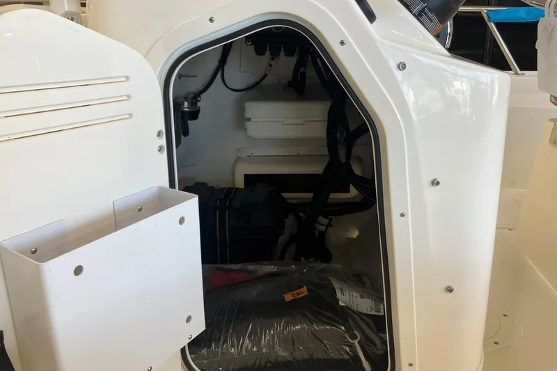 Slide: The Image of 2026 Boston Whaler 170 Montauk storage compartment with visible wiring and equipment. - 6