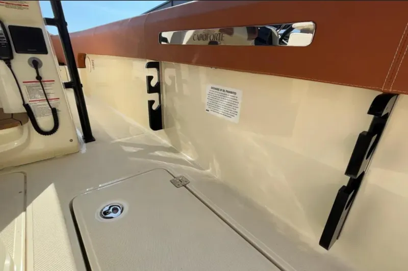 Slide: The Image of 2024 Capoforte FX270 boat interior with beige and brown accents, featuring storage compartments. - 14