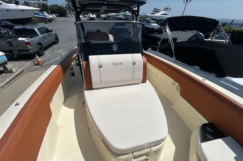 Slide: The Image of 2024 Capoforte FX270 boat interior, featuring spacious seating and modern design at a marina. - 4