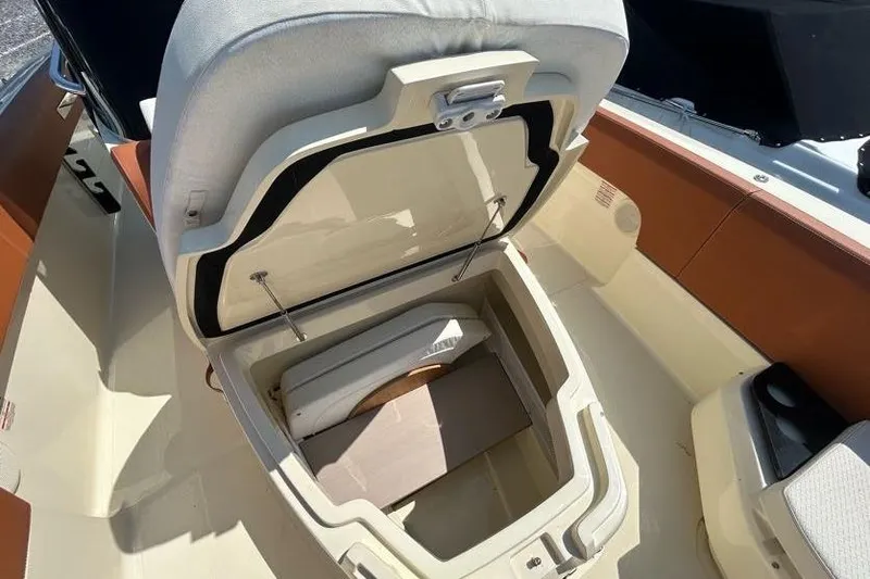 Slide: The Image of 2024 Capoforte FX270 boat seat storage compartment open, showcasing interior space. - 5