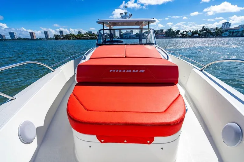 Slide: The Image of 2023 Nimbus Tender 11 boat with red seating, cruising on a sunny day. - 15