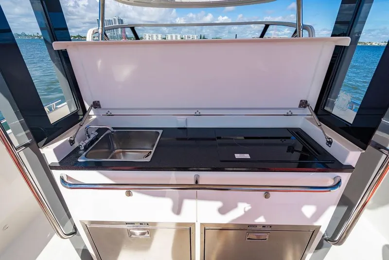 Slide: The Image of Outdoor kitchenette on 2023 Nimbus Tender 11 yacht with sink and stove, overlooking water. - 18