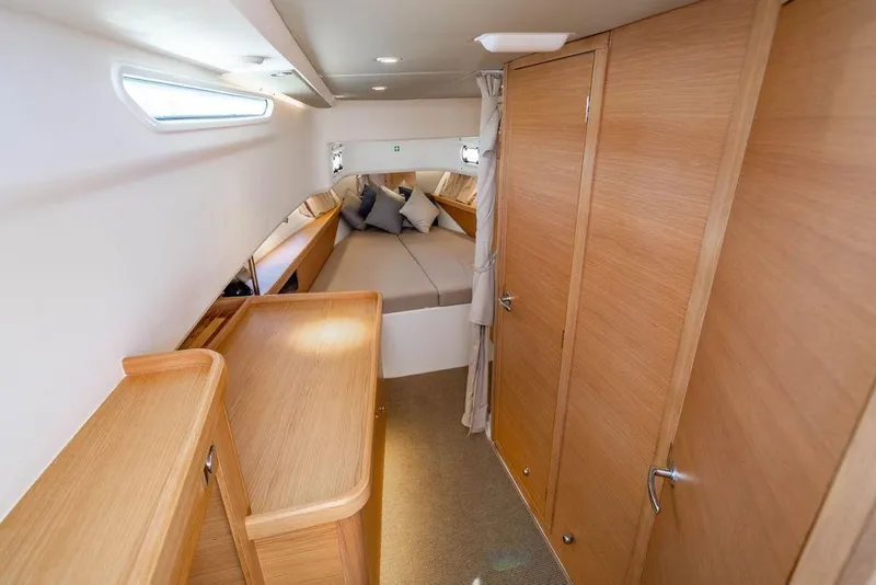 Slide: The Image of Luxurious interior cabin of 2023 Nimbus Tender 11 with wooden finishes and cozy bedding. - 22