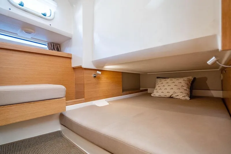 Slide: The Image of 2023 Nimbus Tender 11 cabin interior with cozy bed and wooden accents. - 23