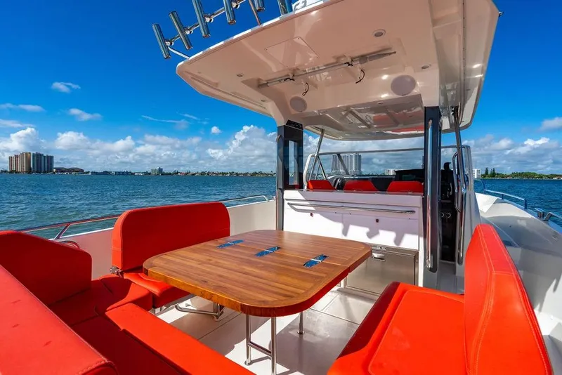 Slide: The Image of Luxurious 2023 Nimbus Tender 11 boat with red seating and wooden table on a sunny day. - 3