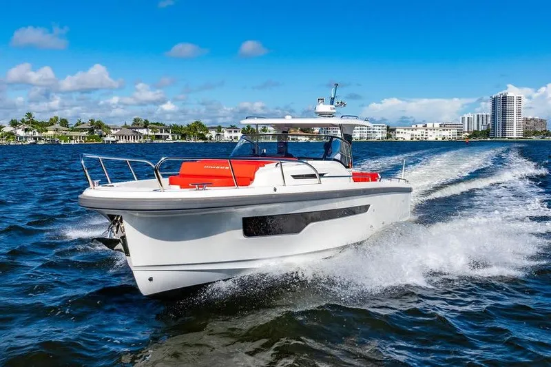 Slide: The Image of 2023 Nimbus Tender 11 cruising on a sunny day, creating waves in a scenic coastal setting. - 33