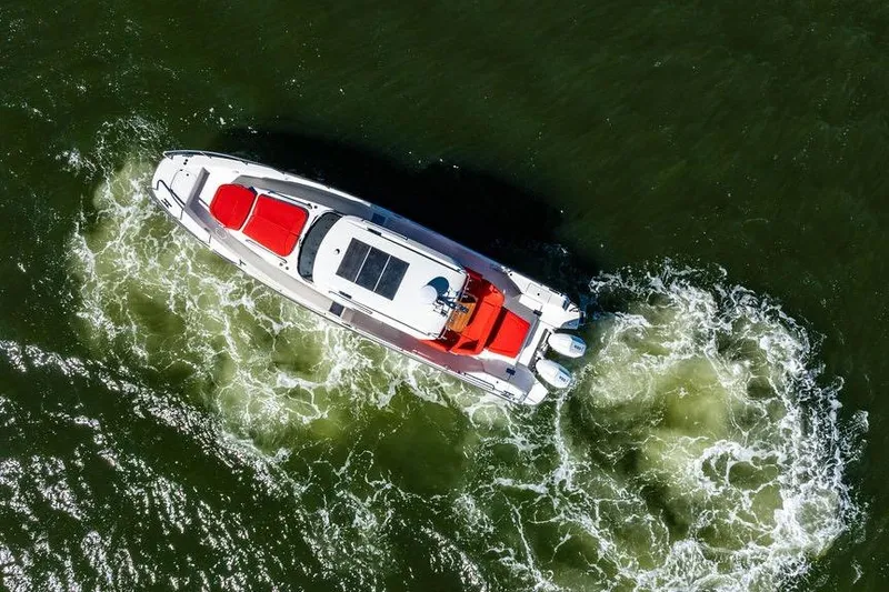 Slide: The Image of Aerial view of 2023 Nimbus Tender 11 boat cruising on green water. - 35