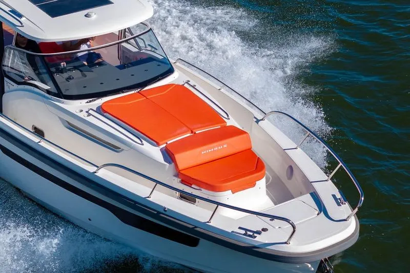 Slide: The Image of 2023 Nimbus Tender 11 boat cruising on water with vibrant orange seating. - 37