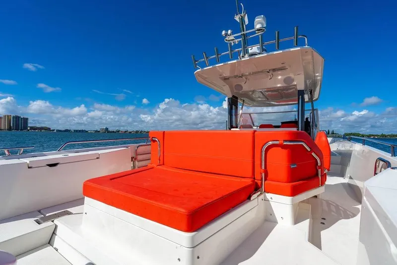 Slide: The Image of 2023 Nimbus Tender 11 boat with vibrant red seating on a sunny day. - 9