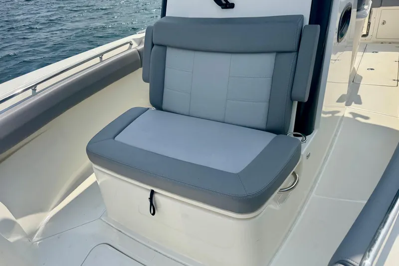 Slide: The Image of 2024 Boston Whaler 250 Outrage boat seat with gray upholstery, on calm water. - 12