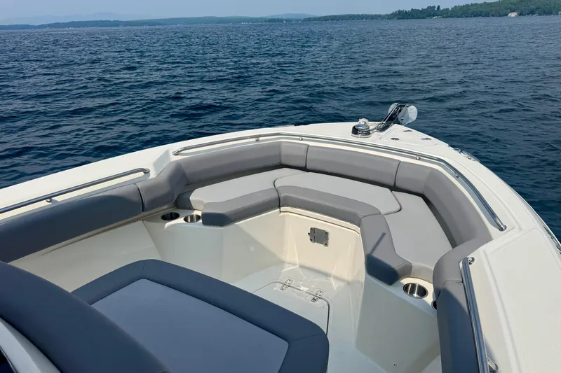 Slide: The Image of 2024 Boston Whaler 250 Outrage boat interior with cushioned seating on open water. - 13