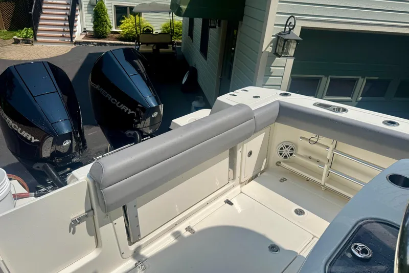 Slide: The Image of 2024 Boston Whaler 250 Outrage boat with dual Mercury engines in a driveway. - 8