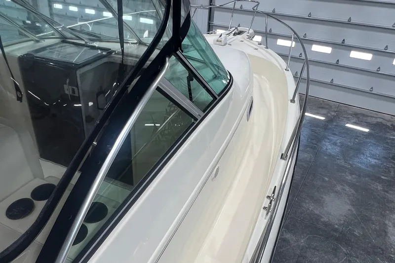 Slide: The Image of 2001 Pursuit 3070 Offshore boat in a garage, showcasing sleek design and railing. - 12