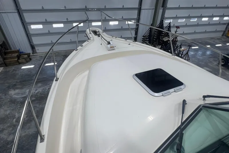 Slide: The Image of 2001 Pursuit 3070 Offshore boat deck in a garage with metal railings. - 13