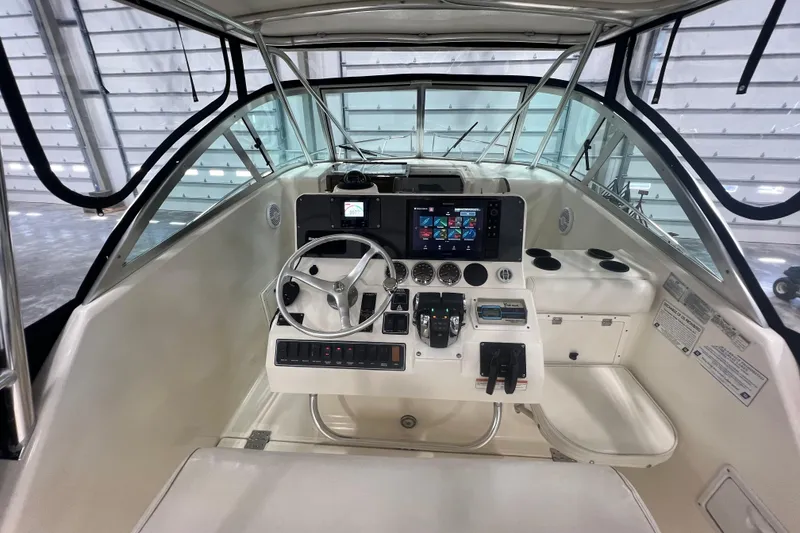 Slide: The Image of 2001 Pursuit 3070 Offshore boat cockpit with steering wheel and navigation controls. - 15