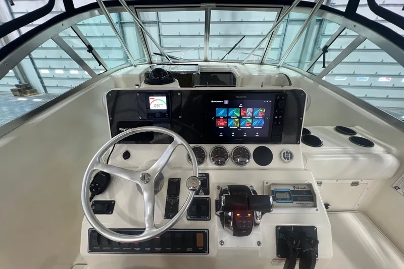 Slide: The Image of 2001 Pursuit 3070 Offshore boat dashboard with steering wheel and navigation controls. - 16