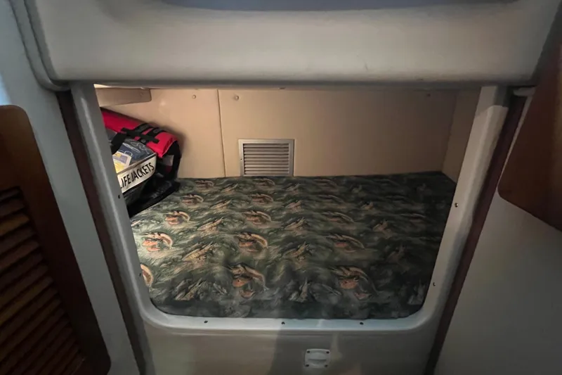 Slide: The Image of 2001 Pursuit 3070 Offshore cabin with patterned bedding and life jackets. - 22