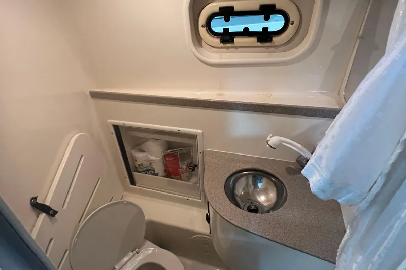 Slide: The Image of Compact bathroom in 2001 Pursuit 3070 Offshore boat with sink, toilet, and storage. - 24