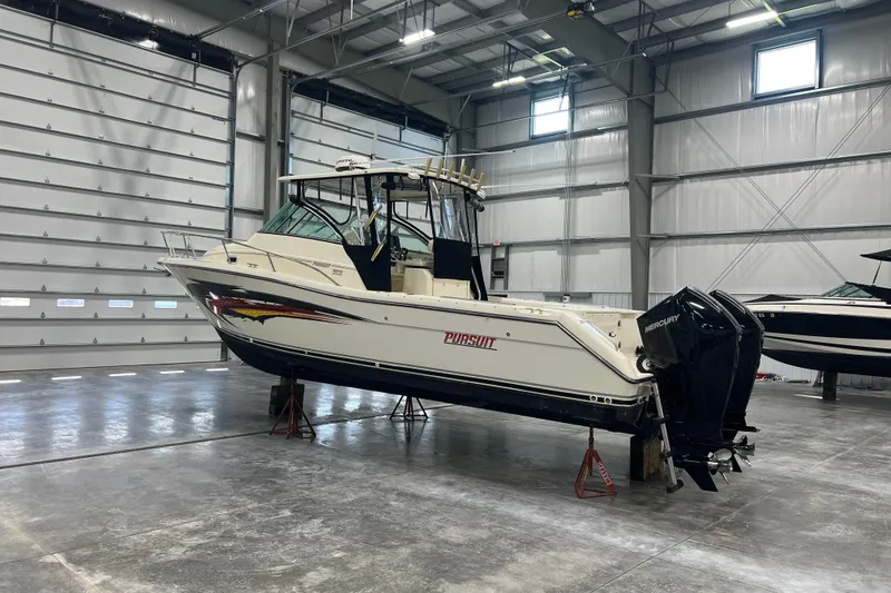Slide: The Image of 2001 Pursuit 3070 Offshore boat in a spacious indoor storage facility. - 4