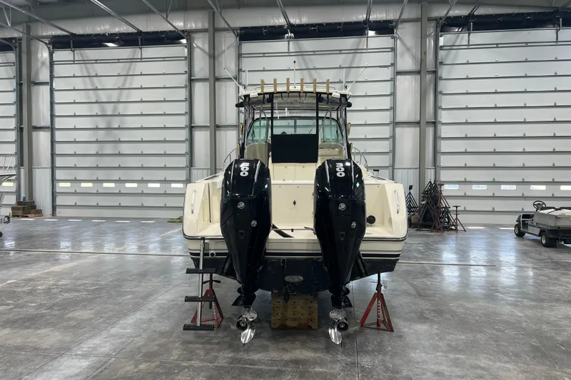 Slide: The Image of 2001 Pursuit 3070 Offshore boat with dual outboard motors in a spacious garage. - 5