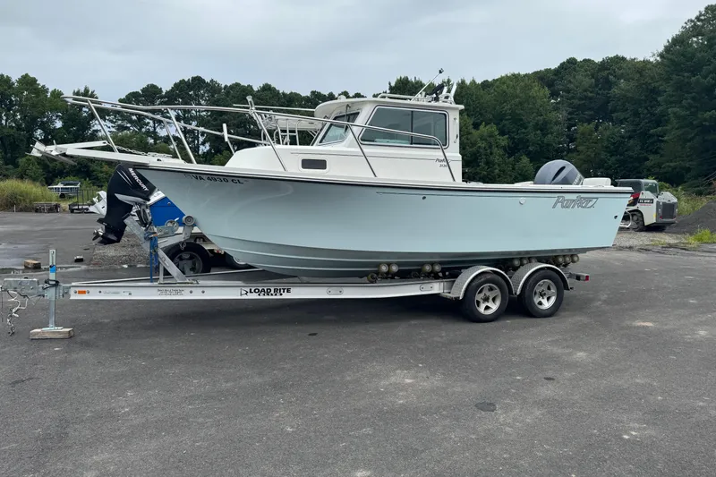 Slide: The Image of 2014 Parker 2120 Sport Cabin boat on trailer in outdoor setting. - 0