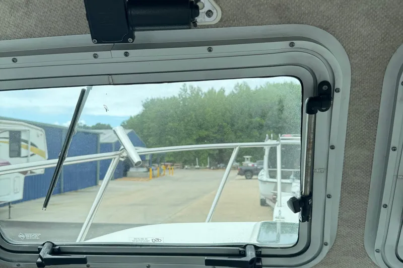 Slide: The Image of View from inside a 2014 Parker 2120 Sport Cabin boat, showing dock and trees. - 12
