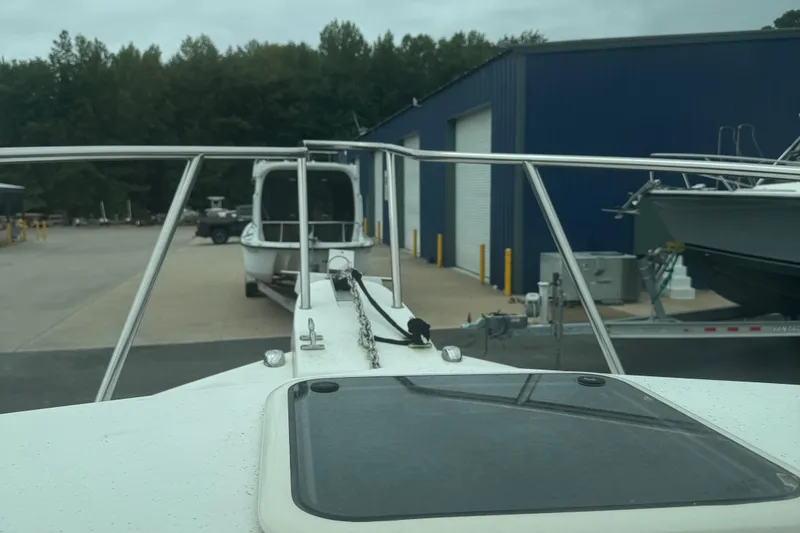 Slide: The Image of 2014 Parker 2120 Sport Cabin boat on trailer at marina, surrounded by trees. - 14
