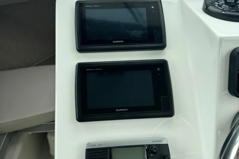 Slide: The Image of Garmin GPS displays and VHF radio on 2014 Parker 2120 Sport Cabin boat dashboard. - 16