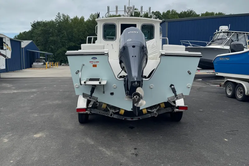 Slide: The Image of 2014 Parker 2120 Sport Cabin boat with outboard motor on trailer. - 2