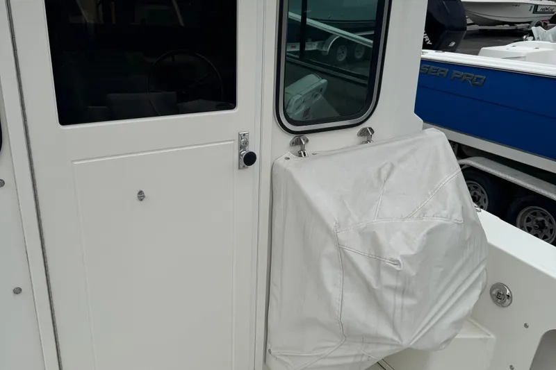 Slide: The Image of 2014 Parker 2120 Sport Cabin boat with covered equipment on deck. - 7