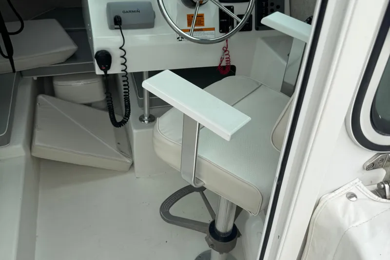 Slide: The Image of Interior of a 2014 Parker 2120 Sport Cabin boat with steering wheel and seat. - 9