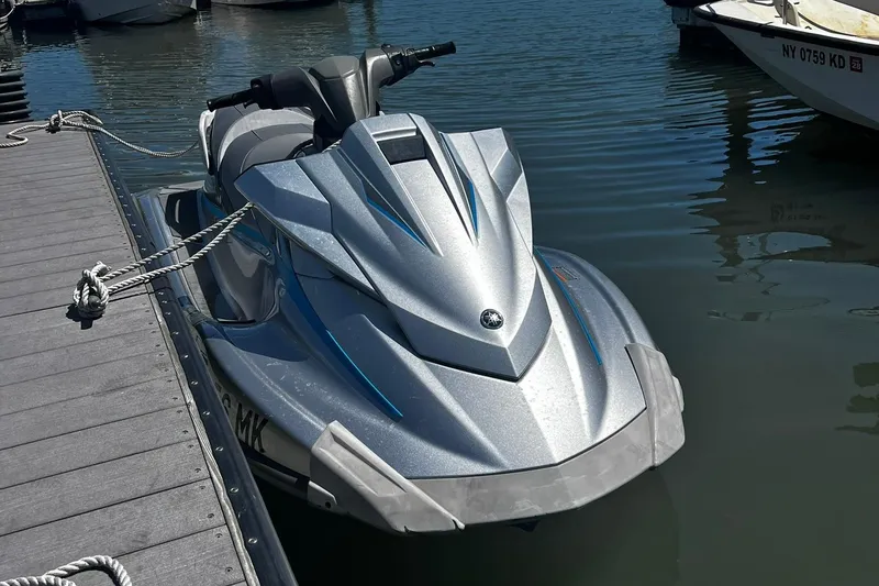 The Image of 2015 Yamaha WaveRunner VX Deluxe jet ski docked on calm water. - 0