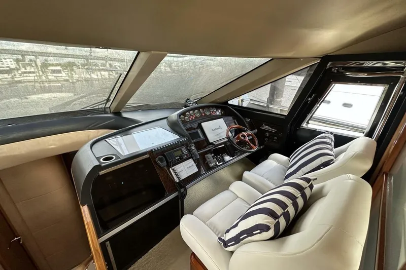 Slide: The Image of Interior helm of 2006 Princess 67 Flybridge yacht with modern controls and striped cushions. - 23