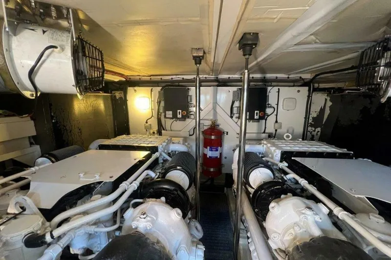 Slide: The Image of Engine room of 2006 Princess 67 Flybridge yacht, featuring dual engines and fire extinguisher. - 34