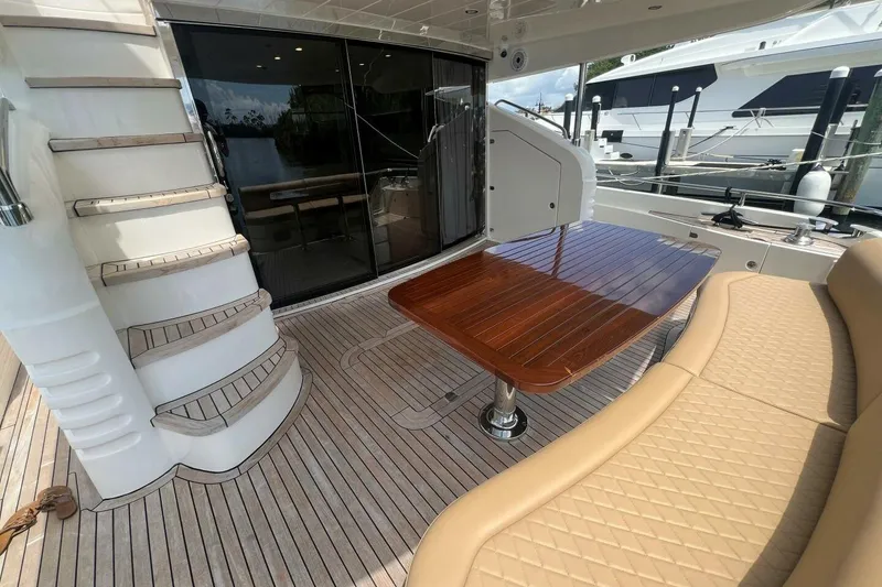 Slide: The Image of Luxurious 2006 Princess 67 Flybridge yacht with elegant deck seating and wooden table. - 6