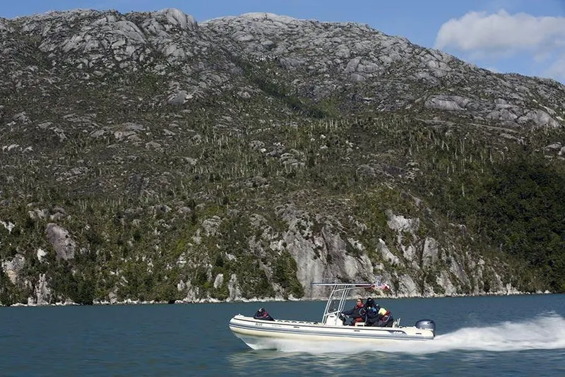 Slide: The Image of 2026 AB Inflatables Oceanus 24 VST cruising near rocky coastline. - 9