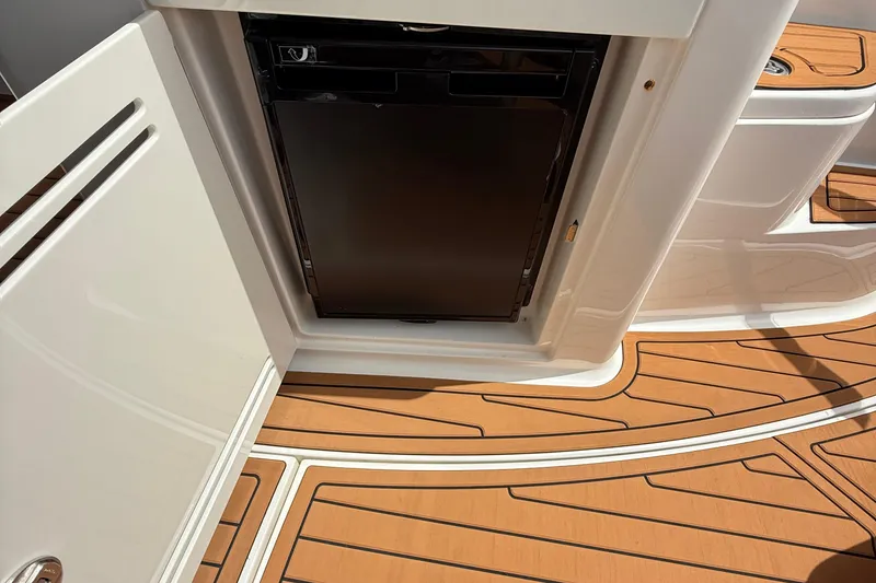 Slide: The Image of 2015 Sea Ray 350 Sundancer with open cabinet and sleek wooden deck. - 12