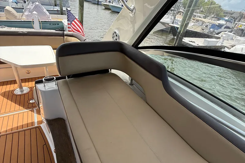 Slide: The Image of 2015 Sea Ray 350 Sundancer interior with seating and table, docked at marina. - 14