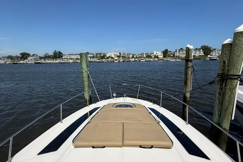 Slide: The Image of 2015 Sea Ray 350 Sundancer docked, overlooking calm waters and coastal homes. - 18