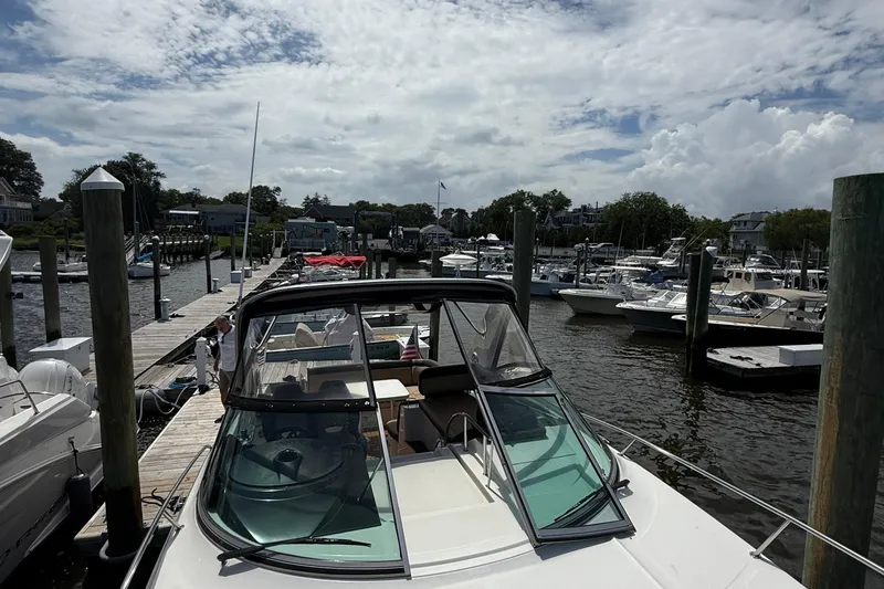 Slide: The Image of 2015 Sea Ray 350 Sundancer docked at a marina under a cloudy sky. - 21