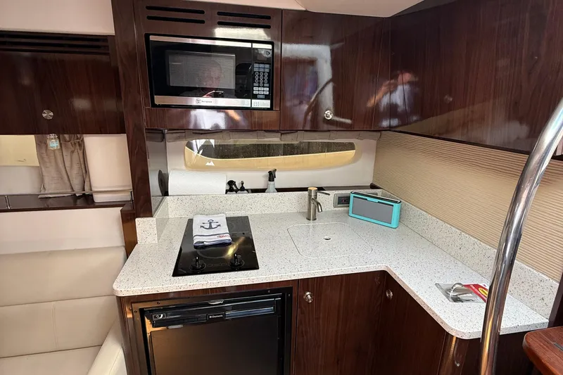 Slide: The Image of 2015 Sea Ray 350 Sundancer yacht kitchen with modern appliances and sleek design. - 25