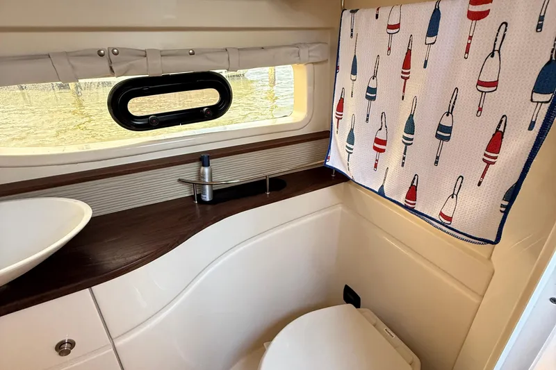 Slide: The Image of Bathroom interior of 2015 Sea Ray 350 Sundancer with nautical-themed decor. - 27