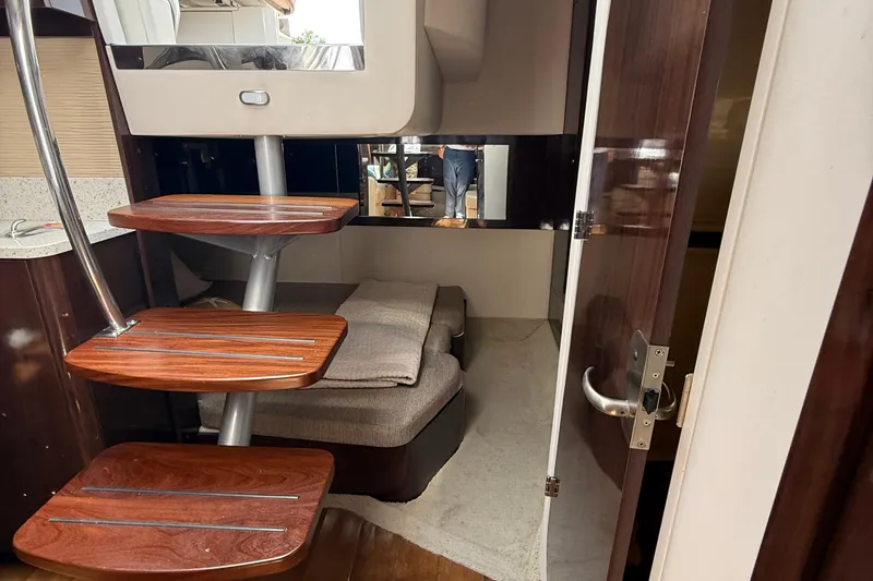 Slide: The Image of Interior of 2015 Sea Ray 350 Sundancer with wooden steps and cozy seating area. - 30