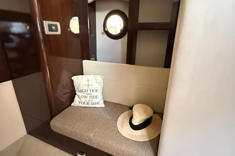 Slide: The Image of Interior of 2015 Sea Ray 350 Sundancer with cushion and hat on a bench. - 32