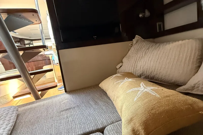 Slide: The Image of Cozy interior of 2015 Sea Ray 350 Sundancer with cushions and wooden stairs. - 34