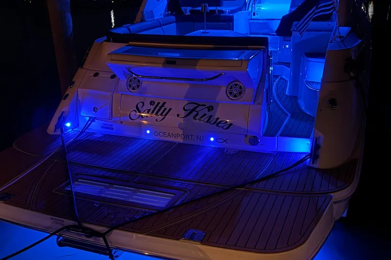 Slide: The Image of 2015 Sea Ray 350 Sundancer yacht with blue LED lights at night, named "Salty Kisses." - 38